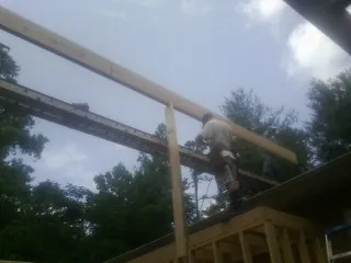 Carpenter setting a ridge beam over a new addition frame — Ice Dam Removal by Roofing Brothers in Joppa