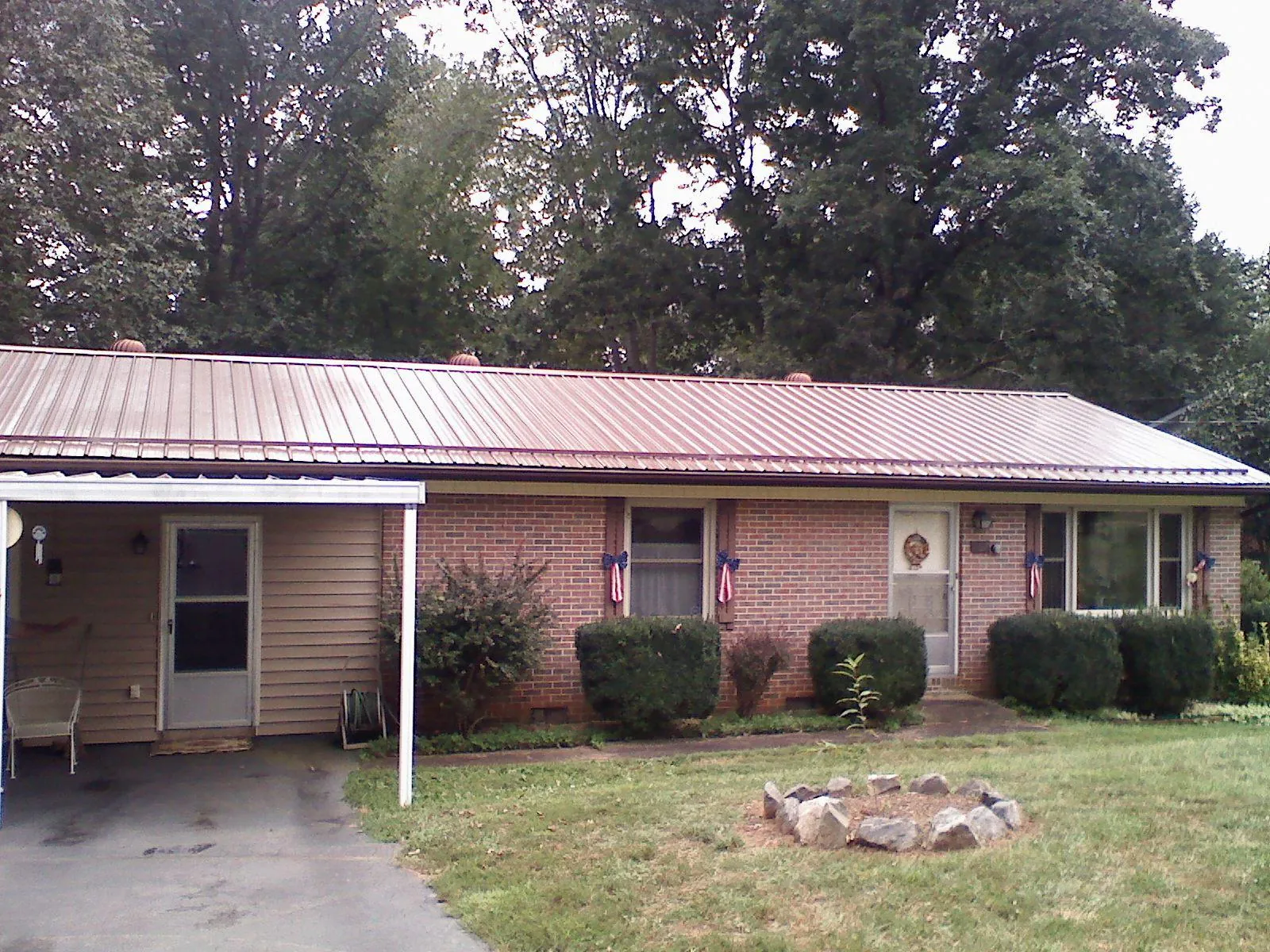 Bronze metal roof and carport on a brick ranch home — Roof Repair work by our crew in Joppa